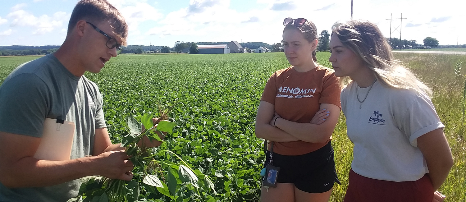 Audrey Hansen and Anna Williams with Ben Roys of Chippewa Valley Bean in field