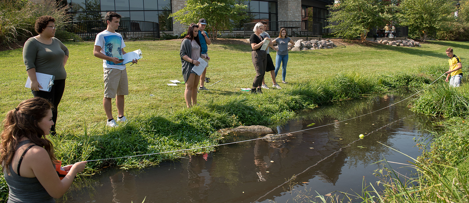 Biology students measure the current in Little Niagra Creek.
